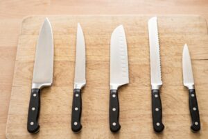 Five different types of kitchen knives lined up on a countertop